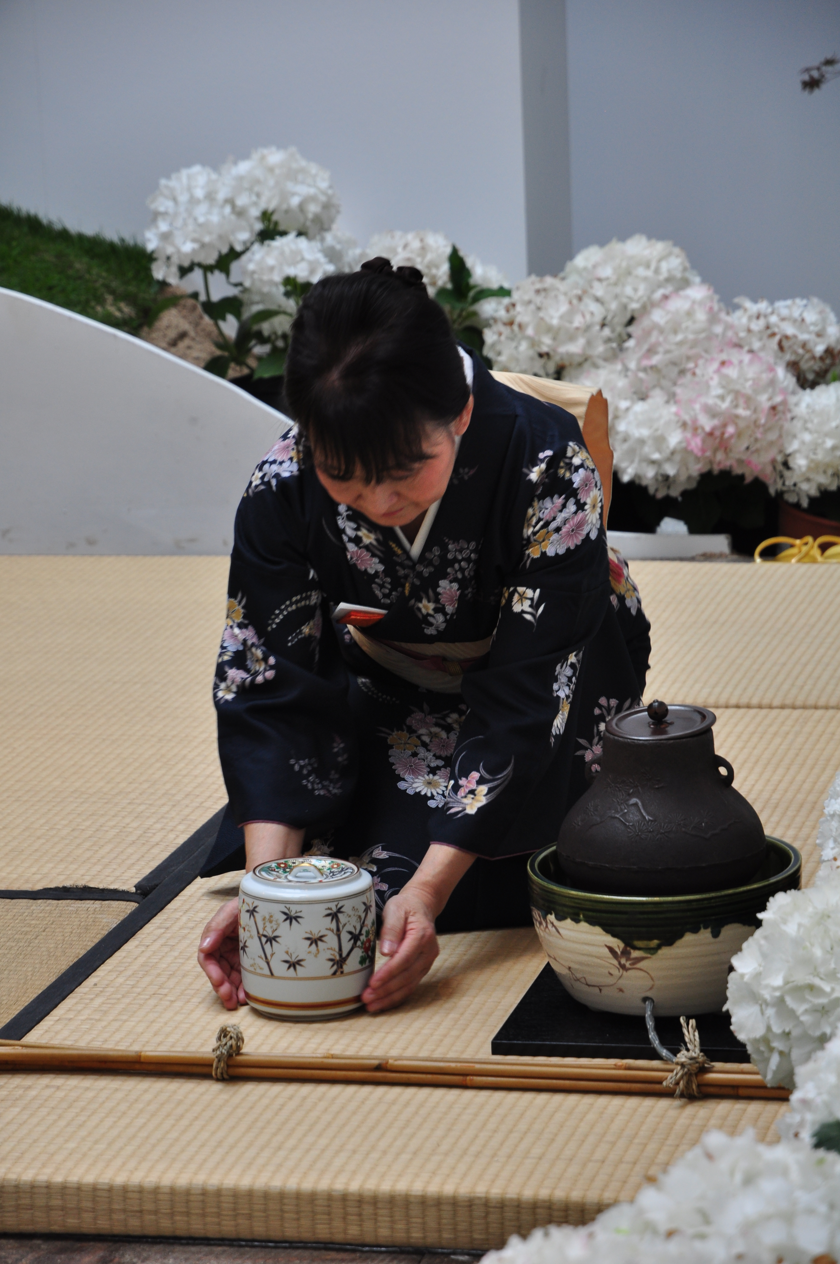 Mujer vestida con kimono preparando té.