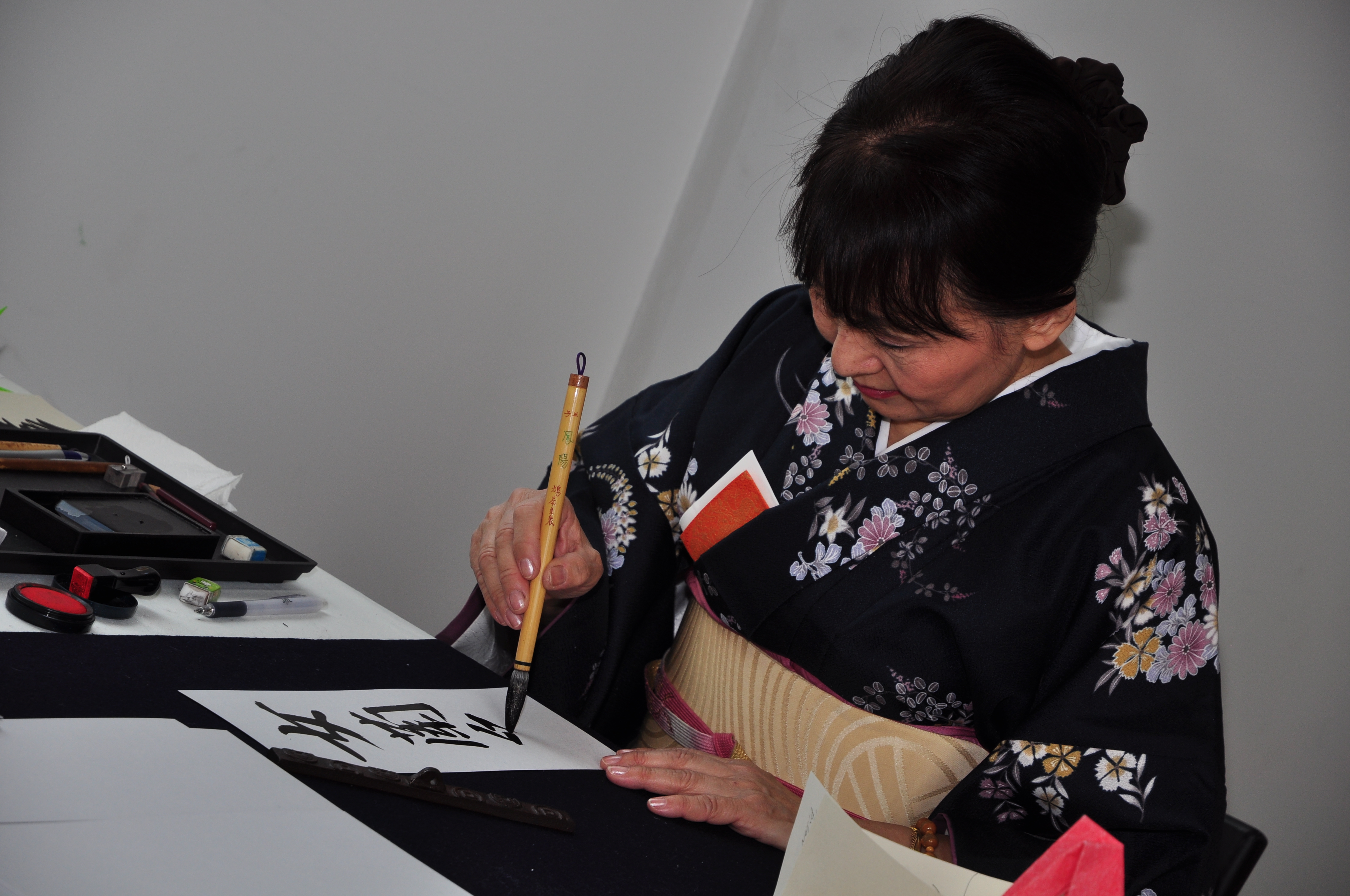 mujer con kimono escribiendo caligrafía japonesa